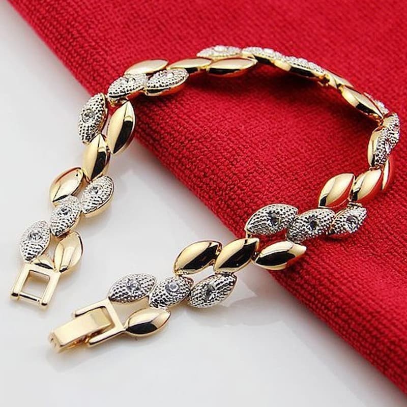 Brazalete rígido de acero inoxidable con chapado en oro de 14 quilates y engaste de circonias cúbicas blancas transparentes.