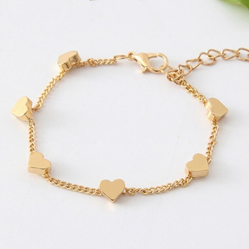 Pulsera para mujer bañada en oro con diseño de corazones entrelazados y acabado pulido espejo.