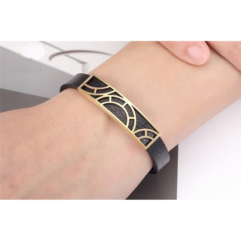 Pulsera de acero y piel de color negro con diseño moderno en color dorado