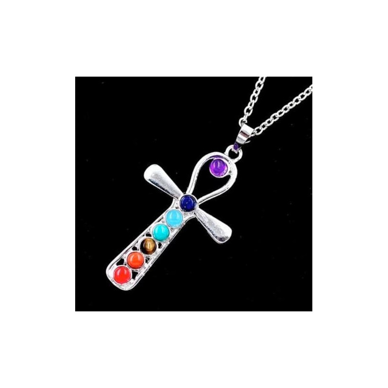 Collar con colgante en forma de cruz decorado con siete gemas de colores representativas de los chakras, acabado en plata.