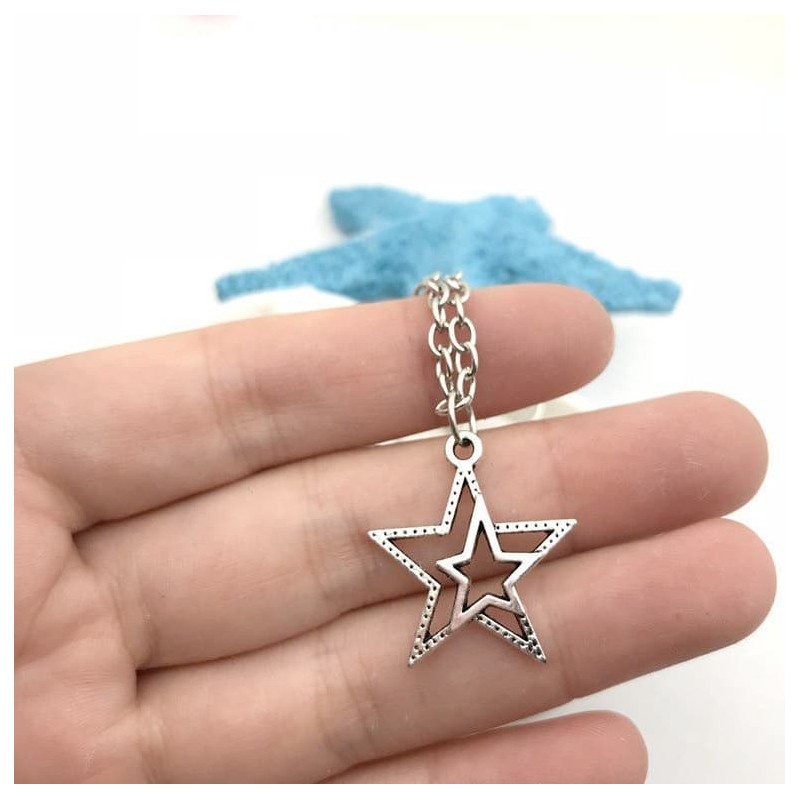 Collar plateado de acero con colgante que combina dos siluetas de estrellas superpuestas con acabado pulido y brillante.