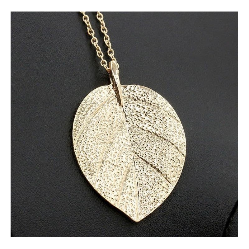 Collar de cadena fina dorada con un colgante detallado en forma de hoja de árbol con acabado pulido y brillante.