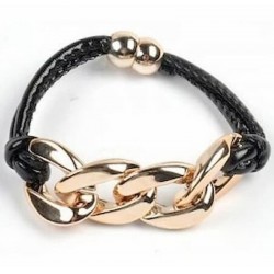 Brazalete de eslabones grandes de acero dorado entrelazados con tiras de piel negra.