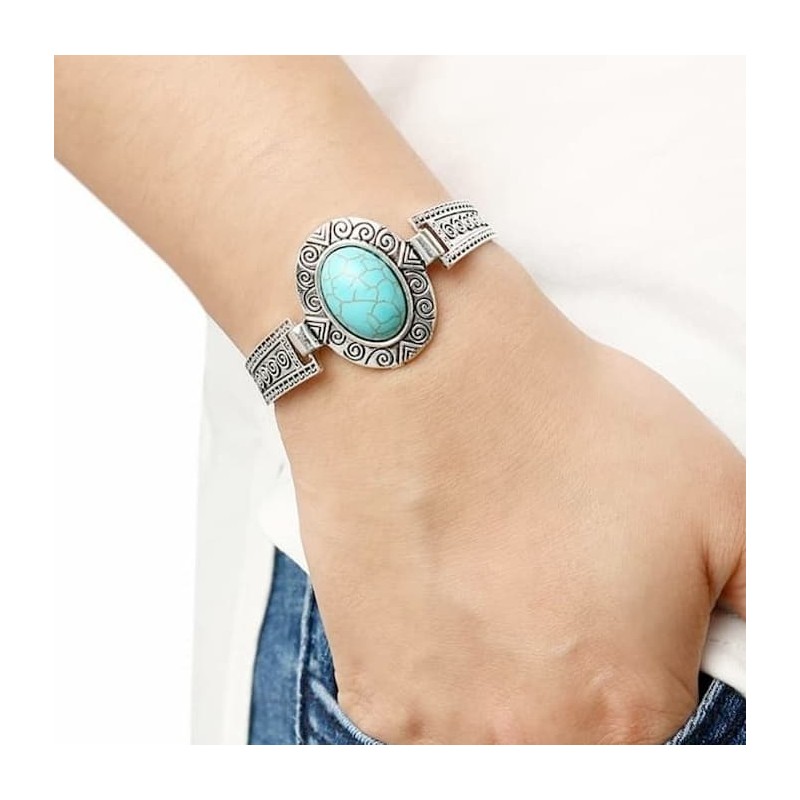 Pulsera de metal chapado en plata con grabados antiguos y una piedra central ovalada en color azul turquesa.