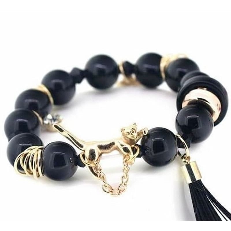 Pulsera de cuentas esféricas de resina brillante con separadores y cierre de acero inoxidable en color dorado.