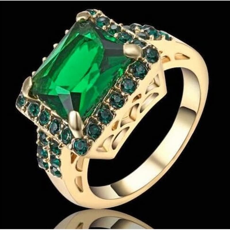 Anillo de mujer en acero con baño de oro de 14 quilates y piedra central color verde esmeralda.