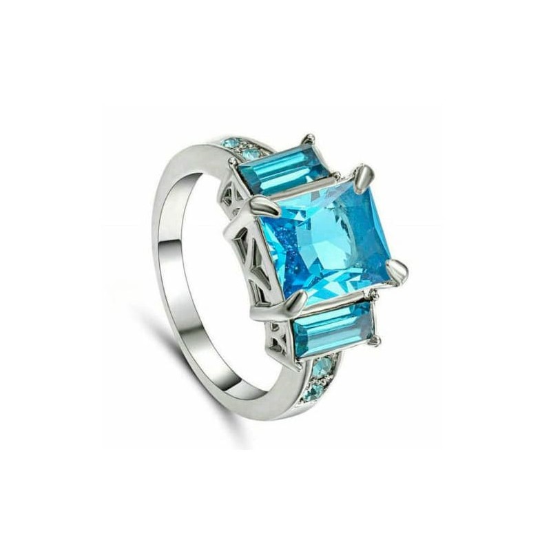 Anillo de mujer de acero con acabado plateado y una piedra central de cristal azul facetado.