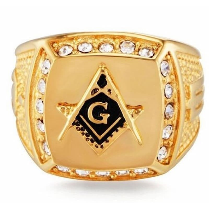 Anillo de acero chapado en oro con pequeños cristales blancos que resaltan símbolo de la masonería