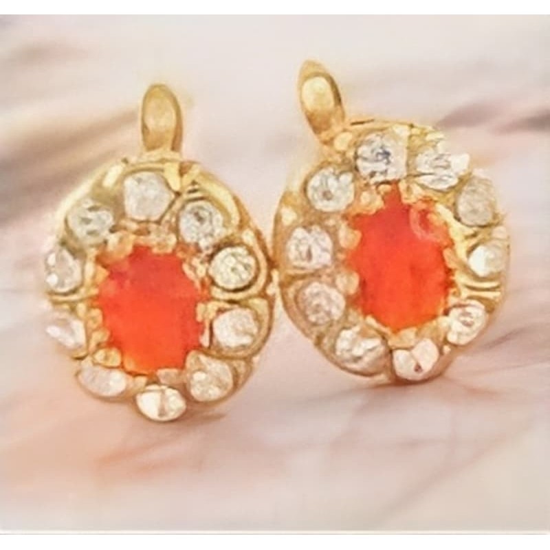 Pendientes de botón en acero con un diseño circular que alterna piedras facetadas en color rojo carmesí y blanco cristalino.