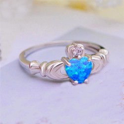 Anillo Claddagh de plata de ley con piedra central color azul claro facetada y manos laterales.