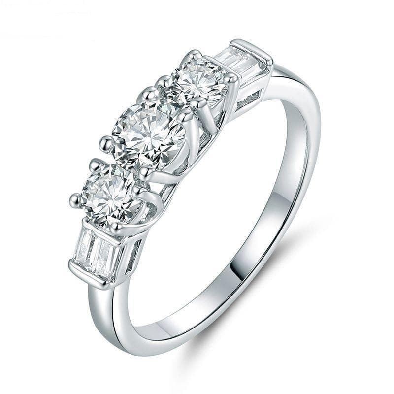 Anillo de pedida clásico con tres circonitas transparentes engastadas sobre banda plateada.