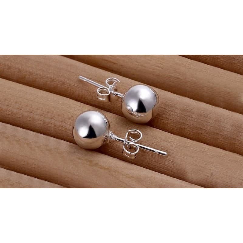 Pendientes de forma esférica tipo bolita fabricados en plata de ley con acabado pulido brillante.
