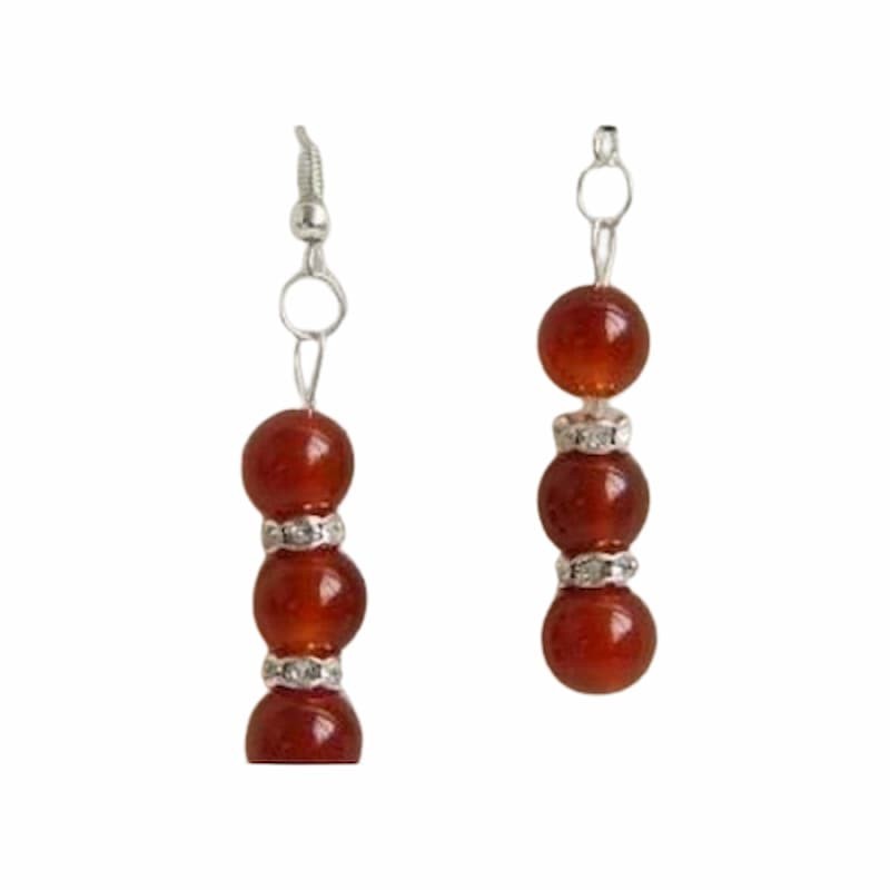 Pendientes colgantes con piedras circulares de color rojo intenso y acabado metálico brillante.