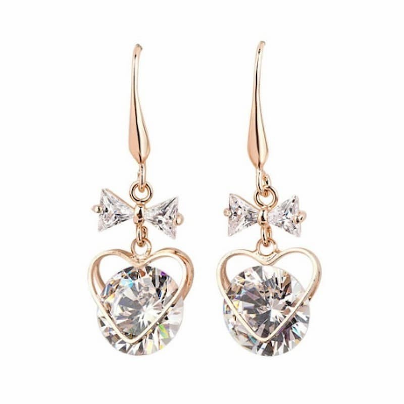 Pendientes con forma de corazón chapados en oro y adornados con brillantes piedras de cristal blanco.