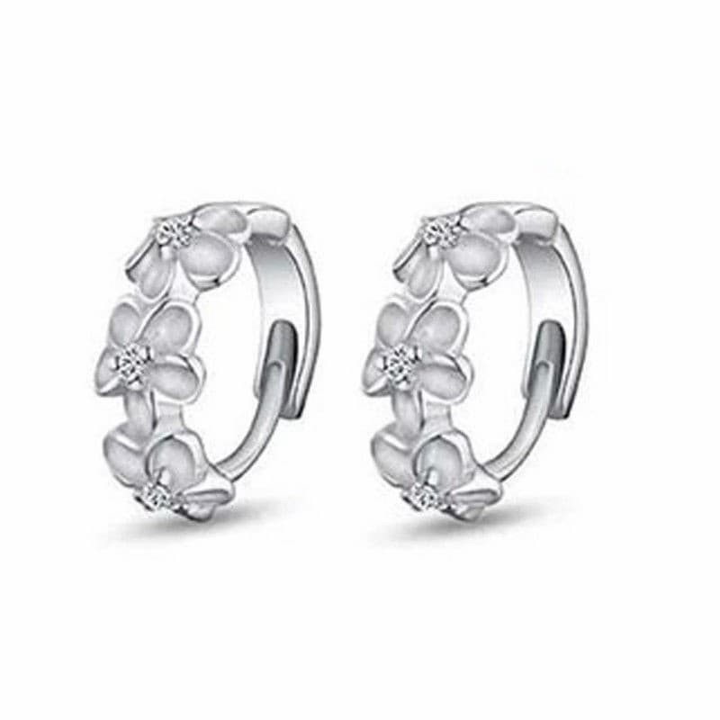Pendientes para mujer con forma de flor de camelia blanca, adornados con cristales brillantes sobre base metálica.