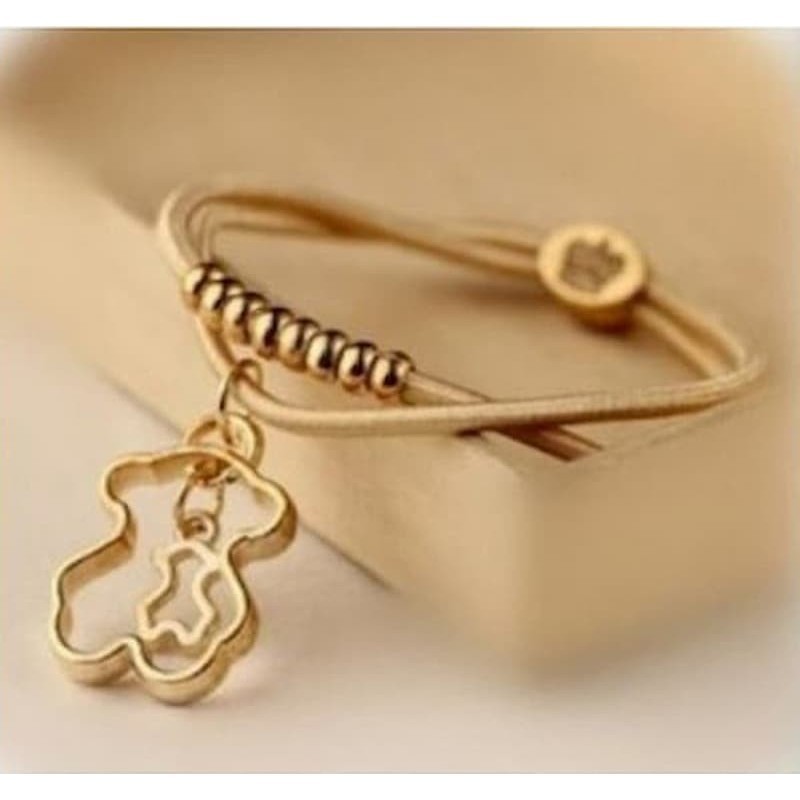 Pulsera de cordón de piel para mujer con charm central en forma de oso con acabado dorado brillante.