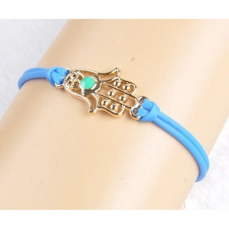 Pulsera dorada para mujer con el símbolo de la Mano de Fátima y una piedra central azul brillante.