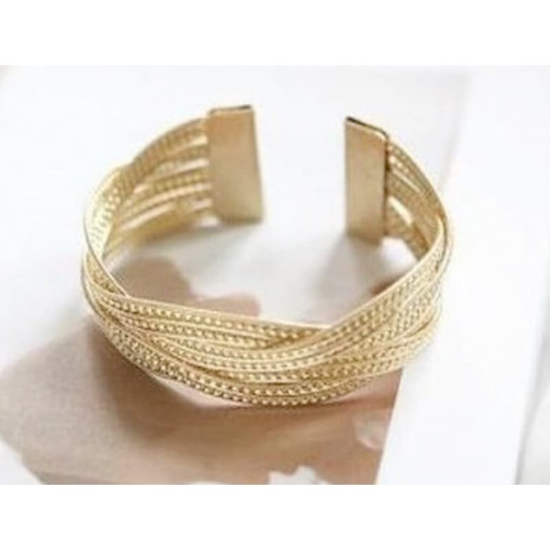 Pulsera ancha para mujer fabricada en acero inoxidable dorado con diseño de eslabones gruesos entrelazados.