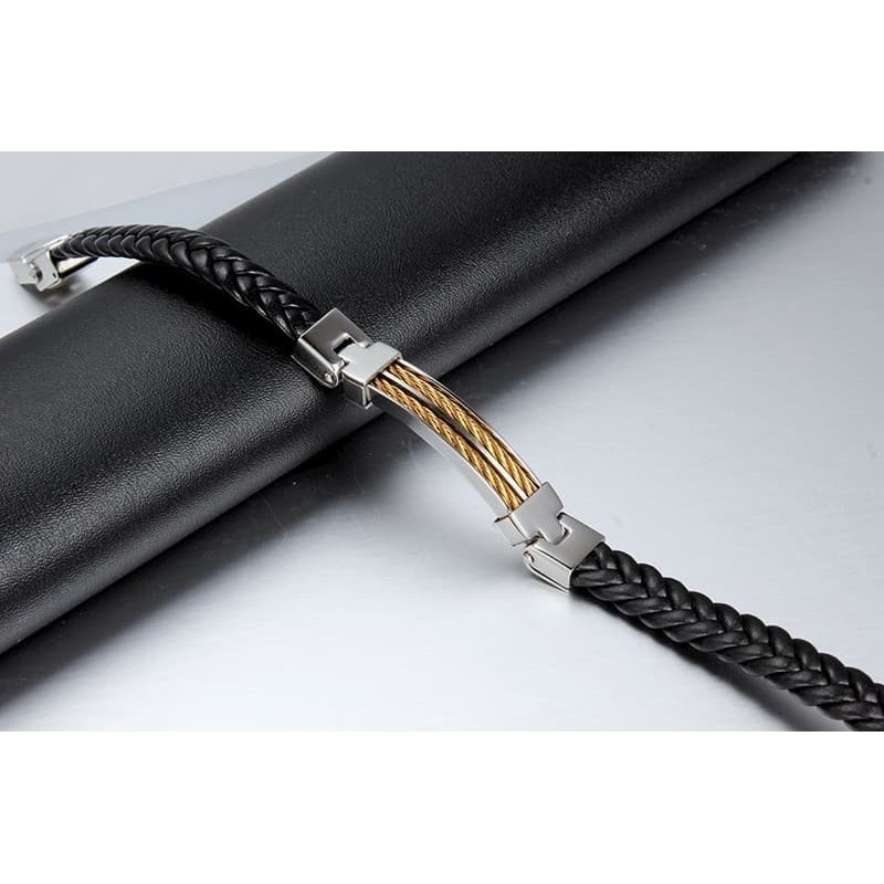 Pulsera masculina de piel negra combinada con detalles de alambre de acero inoxidable en color dorado.