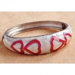 Pulsera de acero inoxidable con acabado en esmalte blanco brillante y detalles de corazones plateados.