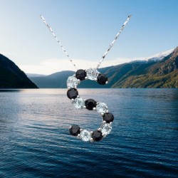 Colgante de plata de ley 925 con la letra S engastada con piedras de topacio y zafiro en tonos azules y brillantes.