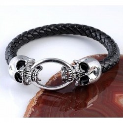 Pulsera para hombre de cuero negro trenzado con detalles de calaveras y cierre en acero inoxidable.