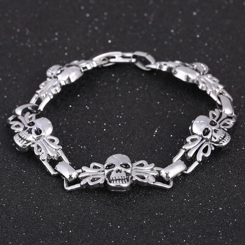 Brazalete elástico para hombre con cuentas de piedra volcánica negra y detalle central de calavera en acero.