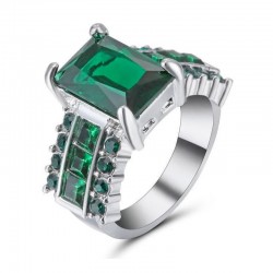 Anillo para mujer bañado en plata con piedra central color verde esmeralda y detalles brillantes laterales.