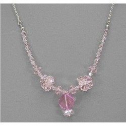 Collar de alta bisutería para mujer con piedras de cristales facetados en tono rosa palo y montura dorada pulida.