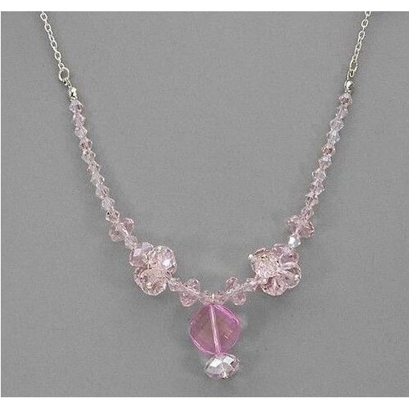 Collar de alta bisutería para mujer con piedras de cristales facetados en tono rosa palo y montura dorada pulida.