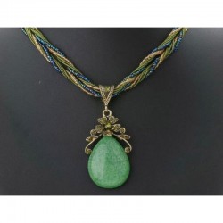 Collar de cadena dorada con colgante de gran piedra central verde esmeralda rodeada de cristales amarillos facetados.