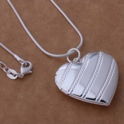 Collar de acero inoxidable acabado plata con colgante de corazón abrible tipo relicario para dos fotografías.