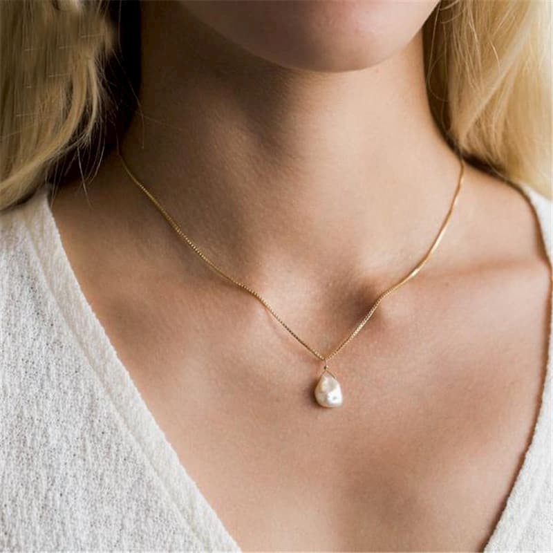 Gargantilla de cadena fina con acabado en oro de 9 quilates y colgante de perla blanca barroca de forma orgánica.