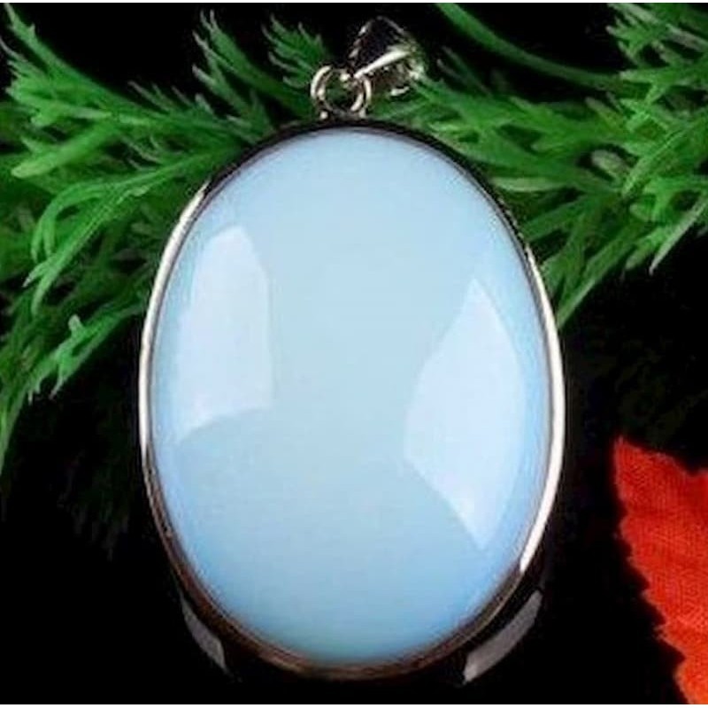 Colgante ovalado de acero chapado en plata con piedra central de imitación ópalo en color azul celeste.