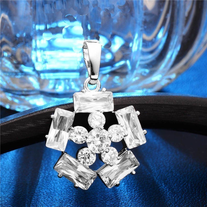 Colgante de acero bañado en plata con diseño geométrico de copo de nieve calado y acabado pulido.
