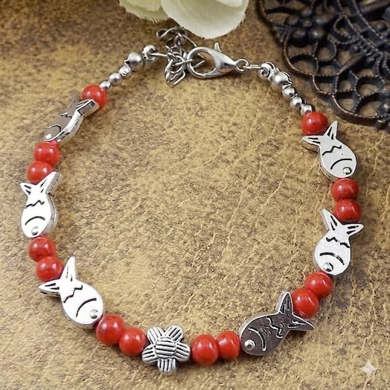 Pulsera para mujer de diseño tibetano con piedras rojas y detalles metálicos labrados.